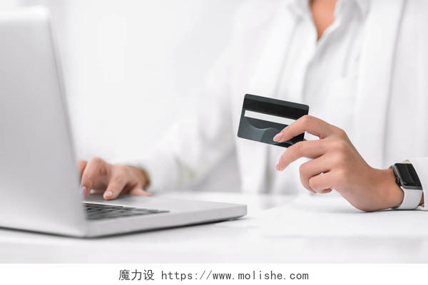 网上购物概念持有塑料信用卡和使用笔记本电脑的无法辨认的女商人